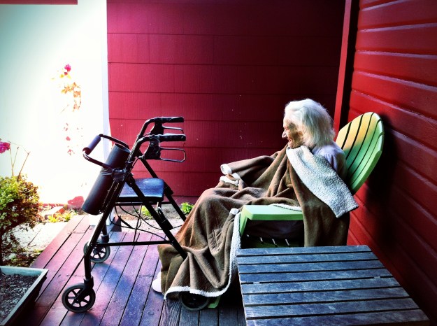 Grandma enjoys the quiet front yard from the porch.